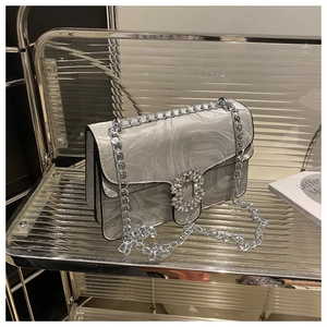 Detail of silver marble crossbody bag featuring rhinestone buckle and chunky metal chain