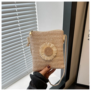 Detail of hand-woven straw crossbody bag with large 3D daisy flower and metal zipper