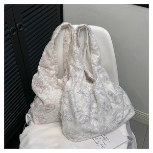 Detail of lace butterfly embroidery and frayed edges on textured canvas tote bags