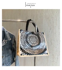 Detail of khaki tote bag featuring black and white sunburst pattern and round top handles