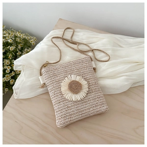 Macro shot of handcrafted cream woven straw bag featuring a 3D daisy flower decoration