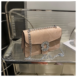 Detail of pink marble pattern handbag with sparkling rhinestone buckle and silver chain