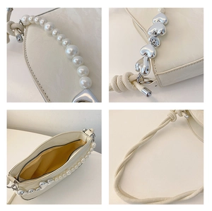 Detailed view of cream leather bag with pearl chain strap and silver heart charm