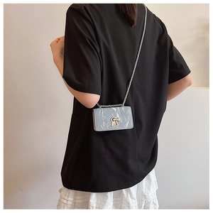 Detail of grey marble pattern mini crossbody bag with silver chain and keyhole lock