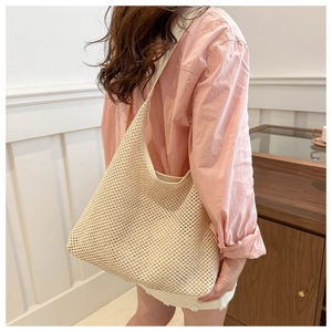 Détail du sac hobo en crochet beige avec texture ajourée et large bandoulière