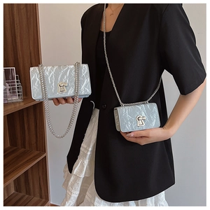 Detail view of light blue textured chain bags in two sizes with silver keyhole clasps