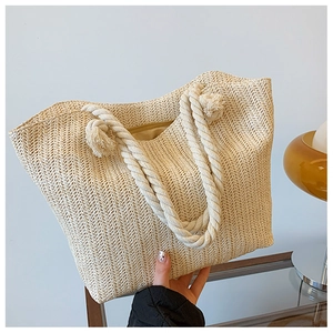 Détail du tissage de paille en V et de la poignée en corde blanche avec gland sur le cabas