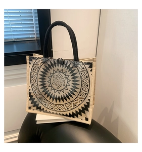 Detail of PVC and linen tote bag featuring geometric sun print and woven rope handles