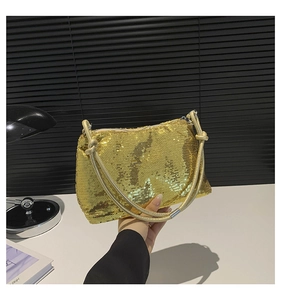 Detailed macro view of stylish gold sequin shoulder bag with decorative knotted handle