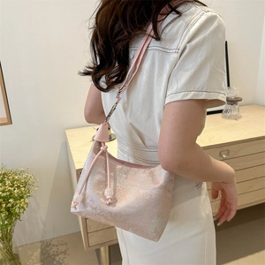 Pink floral jacquard half-moon shoulder bag with beaded tassels worn by model