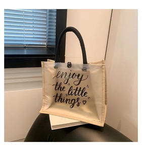 Close-up of PVC tote bag with linen splicing and Enjoy the Little Things printed text