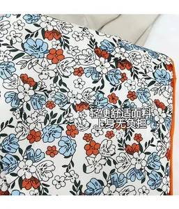 Gros plan du tissu du sac cabas floral avec bords cousus orange et motifs de fleurs