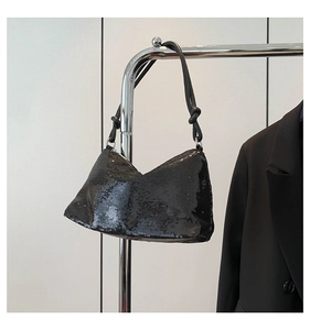 Close-up of black sequin shoulder bag with leather knotted strap on metal hook