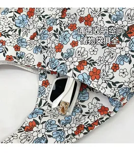 Détail de la poche de rangement interne d'un sac cabas fleuri avec des lunettes