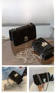 Detail view of black suede shoulder bag with silver chain and vintage keyhole lock