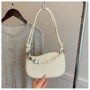 Detail of cream white bag with pearl heart chain and double rope shoulder strap