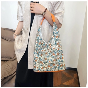Détail d'un cabas en toile à fleurs avec motif vintage et bandoulières orange vif