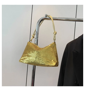 Close-up of golden sequin shoulder bag featuring a unique knotted strap and shiny finish