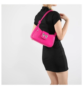 Close-up of a magenta underarm bag with a silver butterfly buckle worn by a model
