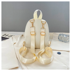 Detail der verstellbaren Nylonriemen und goldfarbenen Metallteile am cremefarbenen Rucksack