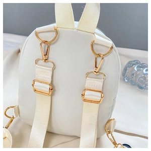 Detailansicht der Rückseite des weißen Mini-Rucksacks mit verstellbaren Goldbeschlägen