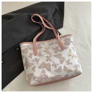 Detailed embroidery of pink and gold butterflies on beige jacquard tote bag with PU strap