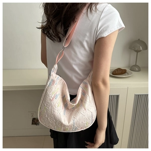 Close-up of pink nylon hobo bag with contrast stitching and monogram pattern