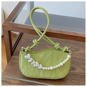 Close-up of avocado green pleated handbag with silver heart charms and pearl chain detail