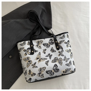 Close-up of butterfly jacquard embroidery and black leather straps with gold studs