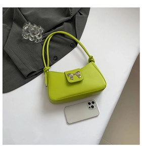 Detail of avocado green baguette bag with silver butterfly clasp and knot handle