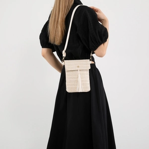 Chic woven straw crossbody bag in cream white with stylish tassel and slim strap