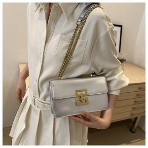 Detail of silver mirror crossbody bag with gold geometric buckle and chain strap