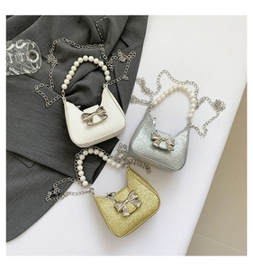 Detail of mini handbags featuring pearl handles, metal bows, and glittering textures