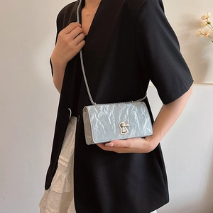 Fashionable light blue pleated chain shoulder bag with metal lock shown on a model