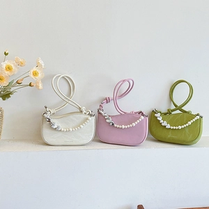 French heart pearl chain handbag in white, pink, and green on display platform