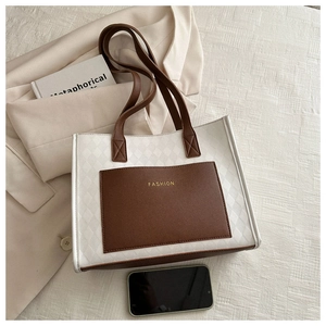 Detail of canvas tote bag with brown PU leather pockets and gold FASHION lettering