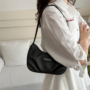 Minimalist black pleated hobo bag with adjustable shoulder strap and fashion label