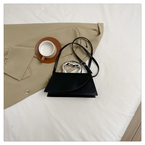 Détail du sac bandoulière noir avec poignée métallique argentée et fine bandoulière