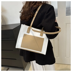 Detail of a beige and khaki tote bag with diamond pattern texture and FASHION logo