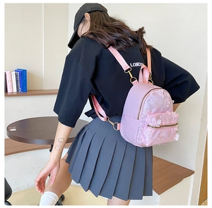 Rosa Mini-Rucksack mit 3D-Paillettenblumen und Metallreißverschluss am Modell