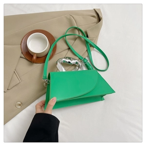 Détail du sac à main géométrique vert avec une poignée unique en métal argenté