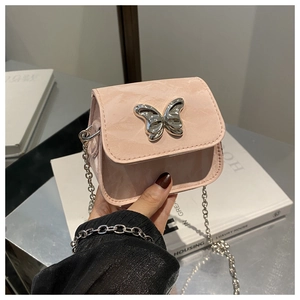 Close-up of pink mini crossbody bag with silver butterfly charm and chain strap