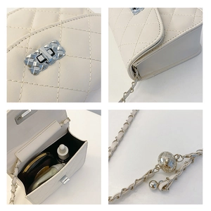 Close-up of white quilted crossbody bag detailing silver lock and inner storage capacity
