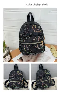 Detail eines schwarzen Mini-Rucksacks mit bunten Pailletten und dekorativen 3D-Blumen