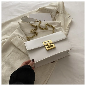 Close-up of white leather crossbody bag with a square gold buckle and chain strap