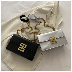 Close-up of stylish crossbody bags with gold interlocking buckles and chain straps