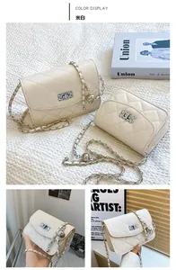 Detail of creamy white quilted crossbody bag with metal chain strap and twist lock