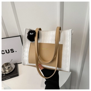 Detail of color-block tote bag with white quilted texture and FASHION logo text