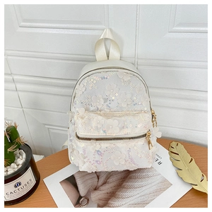 Detailansicht eines weißen Pailletten-Rucksacks mit 3D-Blumenpatches und Perlen