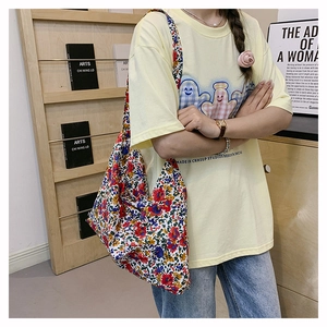 Close-up detail of vintage floral canvas tote bag with dense red and yellow flower patterns
